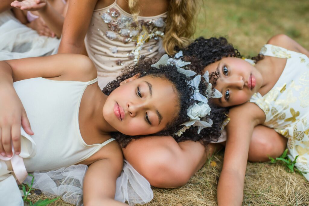 Group of young girls, dressed as fairies, lying on grass