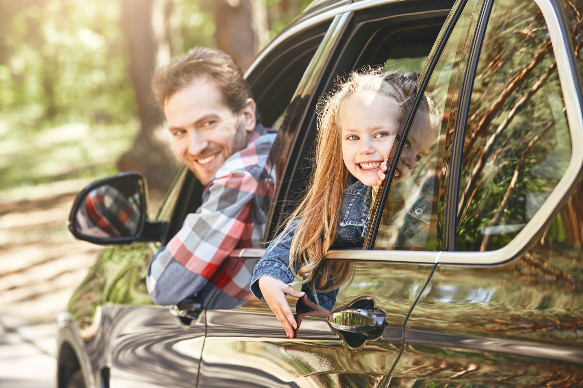 We travel not to escape life, but for life not to escape us. Father and daughter looking out the car