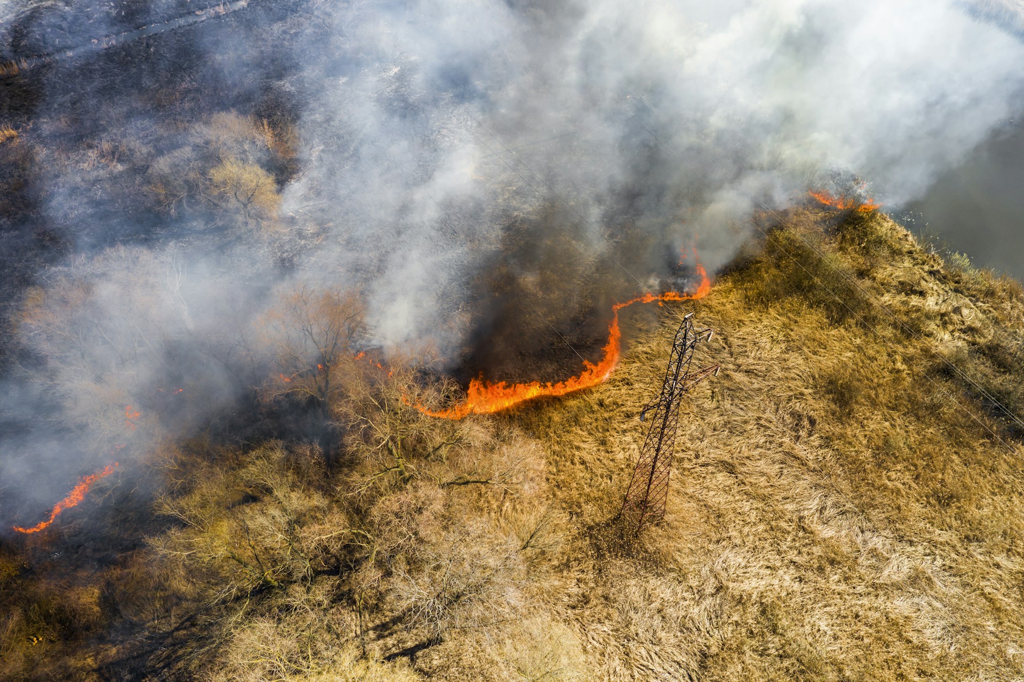 Aerial view of wildfire on the field. Huge clouds of smoke